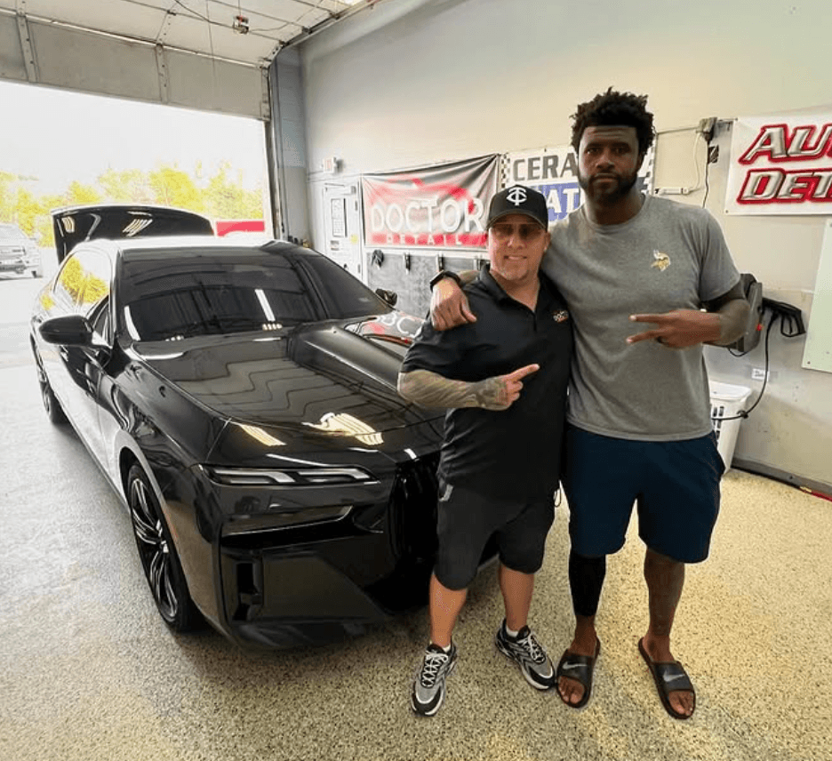 Professional athlete with vehicle at Doctor Detail shop