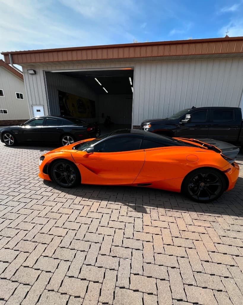 Orange McLaren on brick paver driveway — Doctor Detail Eagan MN
